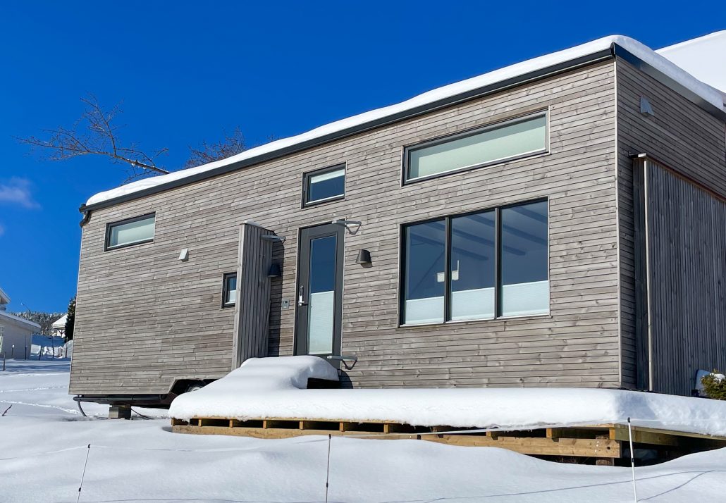 Snøen ligger på verandaen til minihuset. Her må det brøytes.